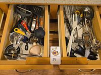 Both open drawers showing full assortment of utensils