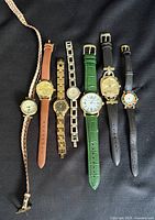 All seven wristwatches laid out to show cases and straps