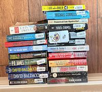 Two side-by-side horizontal stacks of paperback books showing spines; authors and titles visible