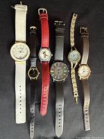 All six wristwatches laid out to show cases and straps