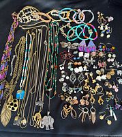 Entire lot laid out showing necklaces, bracelets, earrings and charms