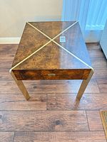 Top view showing burl veneer surface, brass-tone X inlay, overall form