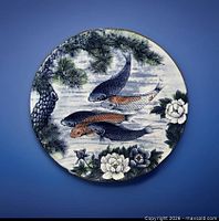 Front view of porcelain charger showing koi fish design