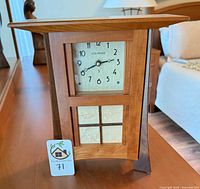 Front view of Schlabaugh & Sons Mission mantel clock showing face, wood panels and tile insets