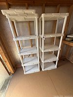 Front view of both white plastic shelving units side by side