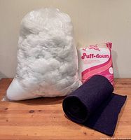 Bag of loose polyester stuffing, Puff-down quilt batt package, rolled felt