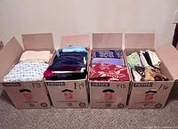 Four open boxes of assorted folded fabrics labeled F13-F16