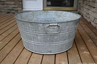 Front exterior view of galvanized metal tub with handle visible