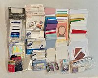 Full lot overview: packaged card sets, stacks of blank cards, embellishments