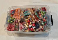 Plastic tub filled with numerous bagged bead assortments and strands