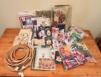 Overview of hoops, kits, floss bags and tapestry canvas on table