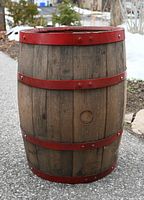 Full view of wooden barrel showing wood staves and red metal bands