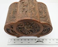 Front view showing carved front panels, dome top, brass clasp, ruler for scale