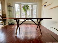 Side view of dining table showing X-base and top