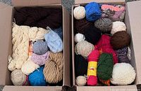 Two boxes filled with assorted skeins and balls of yarn