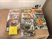 Twelve bagged comics laid out on surface, covers visible