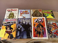 All eight graphic novels laid out, front covers visible