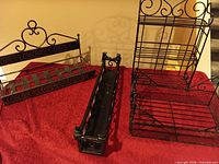 All four black metal display pieces on red cloth
