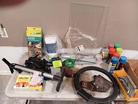 Tabletop view showing majority of items including spray paint, telescopic handle, holster, Velcro pack, wire coil