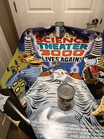 poster surface with signatures, decals partly visible, canned beans for scale