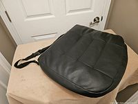 Top view of black cushion showing fabric surface and panel stitching