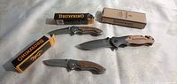 Overview of three Browning folding knives with two branded boxes