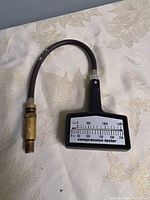 Front view showing gauge face, hose, brass connector