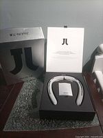 Closed box and opened box showing neck fan and accessories