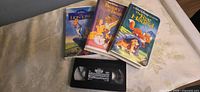 Four VHS titles laid out showing three cases and loose Oliver & Company tape