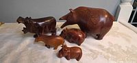 All five wooden hippo figurines side view