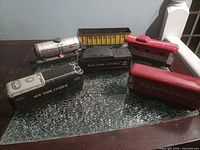 Six tin train cars arranged on glass surface showing overall lot