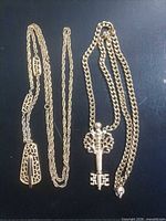 Overall view of both gold-tone necklaces laid flat