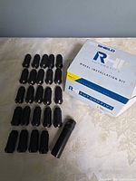 Box, 24 lug nuts and adapter key displayed