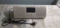 Front view of Sony Dream Machine clock radio showing speakers, display and attached AC cord