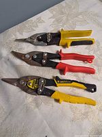 Three aviation snips laid flat showing handles and blades