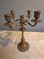 Full front view of candelabra showing five arms and patina finish