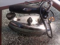 Side view of chrome General Electric iron with cord and black handle