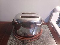Front and side view of chrome toaster with cloth cord