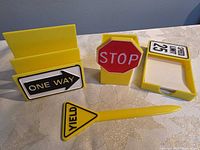 Front view of all four desk accessories: letter holder, stop sign pen holder, memo pad holder, yield sign pen