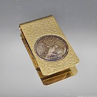 Full view of gold-plated money clip front showing silver coin medallion and textured surface