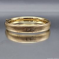 Full view of gold-filled hinged bangle showing engraving J.F.P.