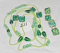 Necklace laid out with earrings beside, showing bead shapes and enamel pattern