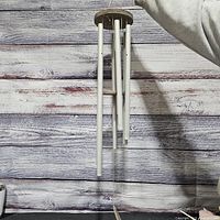 Full view of wind chime showing four tubes, wood top, striker and sail