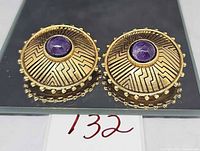 Front view of both earrings showing Aztec pattern and amethyst centers