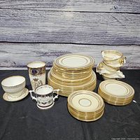 Assorted Lenox ivory porcelain dinnerware stacked on black surface