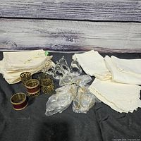 Group of folded white/cream napkins with metal and clear lucite napkin rings