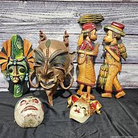 Group view showing all four masks and the pair of figurines