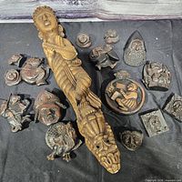 Group view of all seventeen wood carvings on black backdrop