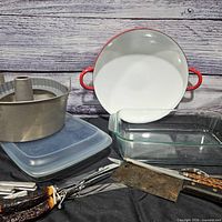 All items grouped together showing paella pan, bundt pan, glass dish, utensils and lid