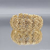 Full view of gold-tone filigree clover bracelet standing upright